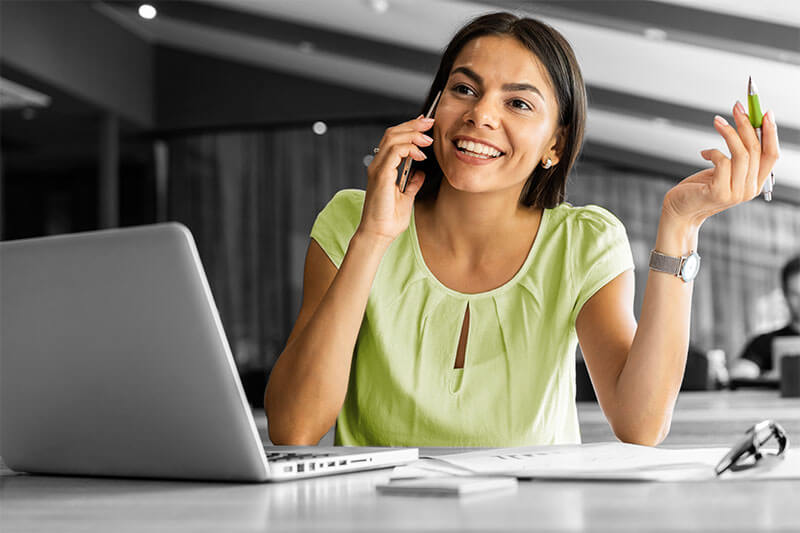 happy woman on phone at laptop